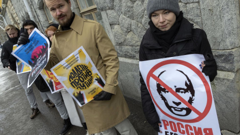 Manifestantes sostienen pancartas con una imagen tachada de Vladimir Putin, mientras los rusos que viven en Finlandia se reúnen para votar en la embajada rusa en Helsinki. 17-03-2024 Manifestantes sostienen pancartas con una imagen tachada de Vladimir Putin, mientras los rusos que viven en Finlandia se reúnen para votar en la embajada rusa en Helsinki. 17-03-2024