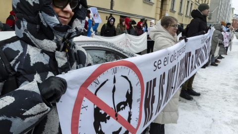 Manifestantes sostienen una pancarta con una imagen tachada de Vladimir Putin en Helsinki, Finlandia, el 17 de marzo de 2024. Manifestantes sostienen una pancarta con una imagen tachada de Vladimir Putin en Helsinki, Finlandia, el 17 de marzo de 2024.