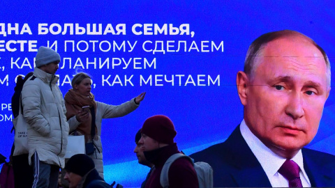 Un grupo de transeúntes pasan cerca de una pantalla digital que muestra una imagen Vladimir Putin, en San Petersburgo, a 14 de marzo de 2024. Un grupo de transeúntes pasan cerca de una pantalla digital que muestra una imagen Vladimir Putin, en San Petersburgo, a 14 de marzo de 2024.