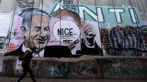 Una mujer camina junto a un graffiti del primer ministro, Benjamín Netanyahu, en el muro de separación israelí de la ciudad cisjordana de Belén. EFE/Abed Al Hashlamoun Una mujer camina junto a un graffiti del primer ministro, Benjamín Netanyahu, en el muro de separación israelí de la ciudad cisjordana de Belén. EFE/Abed Al Hashlamoun