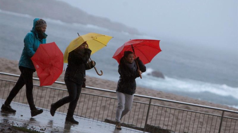 Tres mujeres se protegen de la lluvia en el paseo marítimo de A Coruña. - EFE Tres mujeres se protegen de la lluvia en el paseo marítimo de A Coruña. - EFE