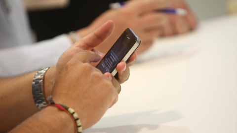 Una persona utilizando su teléfono móvil Una persona utilizando su teléfono móvil