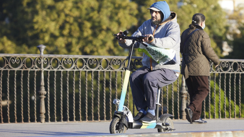 Una persona en su patinete, en Puente de Triana, en Sevilla. Una persona en su patinete, en Puente de Triana, en Sevilla.