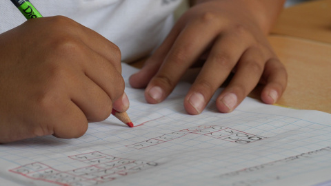 Un niño haciendo deberes en el colegio. Un niño haciendo deberes en el colegio.