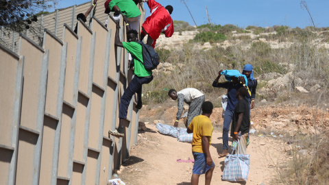 Varias personas migrantes escapan del 'hotspot' de Lampedusa, Italia, colapsado tras la llegada de más de 10.000 personas en tres días. Varias personas migrantes escapan del 'hotspot' de Lampedusa, Italia, colapsado tras la llegada de más de 10.000 personas en tres días.