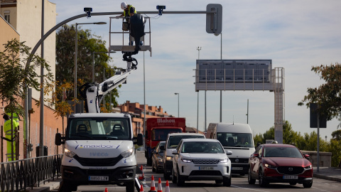 Un técnico monta una cámara de tráfico en un semáforo para controlar el acceso a la Zona de Bajas Emisiones (ZBE) de Madrid. Un técnico monta una cámara de tráfico en un semáforo para controlar el acceso a la Zona de Bajas Emisiones (ZBE) de Madrid.