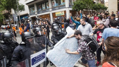 Agentes antidisturbios de los Mossos rodean los accesos del 'Banc Expropiat' de Barcelona tras dispersar a empujones al centenar de personas que se habían concentrado a las puertas de la finca, en apoyo a los okupas. EFE/Quique García Agentes antidisturbios de los Mossos rodean los accesos del 'Banc Expropiat' de Barcelona tras dispersar a empujones al centenar de personas que se habían concentrado a las puertas de la finca, en apoyo a los okupas. EFE/Quique García