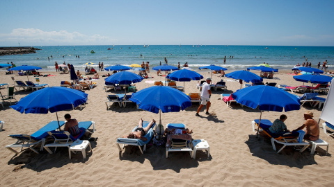 Turistas bajo las sombrillas en la playa de Sitges (Barcelona). REUTERS/ Albert Gea Turistas bajo las sombrillas en la playa de Sitges (Barcelona). REUTERS/ Albert Gea