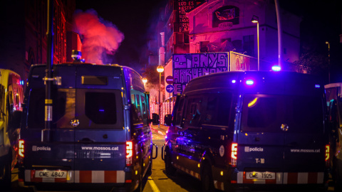 Dos furgons policials amb les dues cases ocupades en segon terme. Dos furgons policials amb les dues cases ocupades en segon terme.