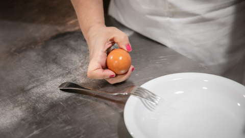 Imagen de una mujer con párkinson sosteniendo un huevo.
