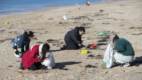 Voluntarios recogen microeplásticos o pellets, que han aparecido en toda la costa atlántica de Galicia, este domingo en la Playa de A Lanzada en O Grove. Voluntarios recogen microeplásticos o pellets, que han aparecido en toda la costa atlántica de Galicia, este domingo en la Playa de A Lanzada en O Grove.