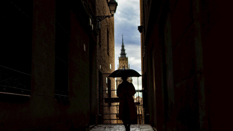Una mujer pasea por Toledo bajo la lluvia. Una mujer pasea por Toledo bajo la lluvia.