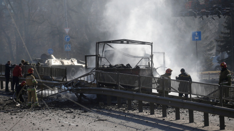 Militares y socorristas ucranianos se paran junto a un vehículo dañado, en el lugar de los combates con las tropas rusas