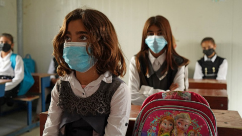 Niñas se sientan en clase el primer día de clases en un campamento de desplazados Yazidi en el área de Sharya. Niñas se sientan en clase el primer día de clases en un campamento de desplazados Yazidi en el área de Sharya.