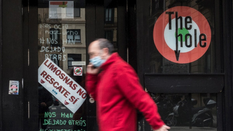 Un hombre camina junto a un establecimiento de ocio nocturno cerrado en la Parte Vieja de San Sebastián Un hombre camina junto a un establecimiento de ocio nocturno cerrado en la Parte Vieja de San Sebastián