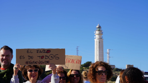 Varias personas protestando contra  la apertura de un restaurante en el faro de Trafalgar