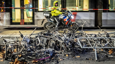Un policía observa parte de los daños causado tras una protesta en la ciudad portuaria de Róterdam contra las restricciones aplicadas por el Gobierno para frenar los contagios en Países Bajos. Un policía observa parte de los daños causado tras una protesta en la ciudad portuaria de Róterdam contra las restricciones aplicadas por el Gobierno para frenar los contagios en Países Bajos.