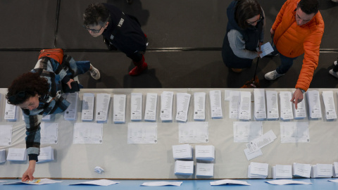 Varias personas escogen papeletas para ejercer su derecho al voto en el pabellón polideportivo Ames en A Coruña durante la jornada electoral en Galicia, este domingo. Varias personas escogen papeletas para ejercer su derecho al voto en el pabellón polideportivo Ames en A Coruña durante la jornada electoral en Galicia, este domingo.