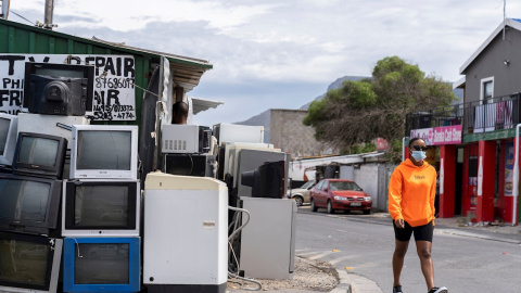 Una mujer pasa por una tienda de reparaciones de televisores en Ciudad del Cabo, Sudáfrica.