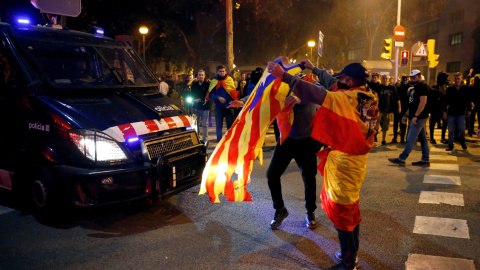 17/10/2019 - Un hombre vestido con la bandera franquista muestra la estelada al furgón de la policía durante las protestas de los CDR en barcelona. / REUTERS (Rafael Marchante)