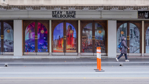 Una mujer pasa junto a un letrero de 'Stay Safe Melbourne' en una calle del centro de la ciudad. Una mujer pasa junto a un letrero de 'Stay Safe Melbourne' en una calle del centro de la ciudad.