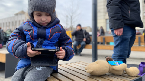 El pequeño Sasha juega con un móvil fuera de la estación de trenes de Leópolis, en el oeste de Ucrania, este jueves. El pequeño Sasha juega con un móvil fuera de la estación de trenes de Leópolis, en el oeste de Ucrania, este jueves.