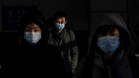 Varias personas con mascarilla en el distrito financiero de Pekín.