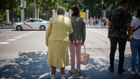 Una mujer mayor espera para cruzar una calle, con ayuda, por el centro de Madrid, a 4 de junio de 2023. Una mujer mayor espera para cruzar una calle, con ayuda, por el centro de Madrid, a 4 de junio de 2023.