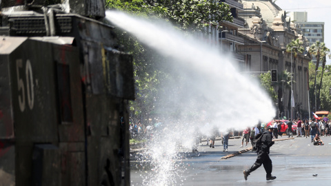 28/10/2019.- Manifestantes chocan con efectivos policiales este lunes frente al Palacio de La Moneda, sede del Gobierno en Santiago (Chile). El presidente de Chile, Sebastián Piñera, realizó este lunes una profunda remodelación de su gabinete para enf