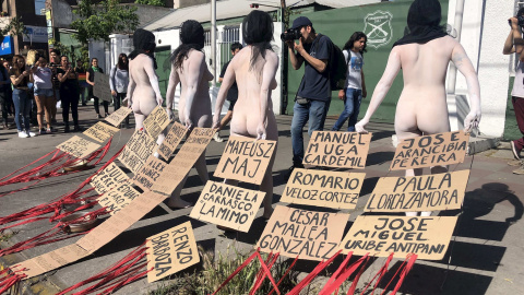 28/10/2019.- Manifestantes desnudos con carteles con los nombres de los 20 fallecidos en las protestas de Chile, este lunes frente a una comisaría de Carabineros, en Santiago (Chile). EFE/Fernando Gimeno