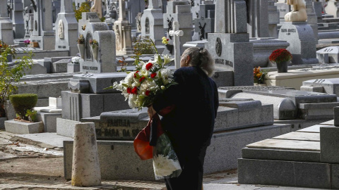 Una mujer con flores visita el madrileño cementerio de La Almudena, el Día de Difuntos. EFE/Paco Campos Una mujer con flores visita el madrileño cementerio de La Almudena, el Día de Difuntos. EFE/Paco Campos