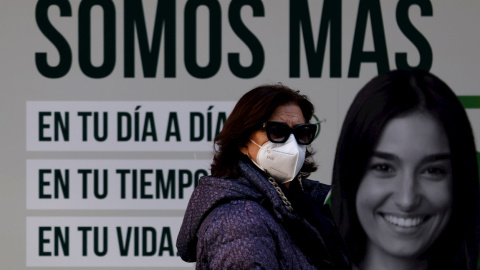 Una mujer camina este jueves con mascarilla por una céntrica calle de La Coruña. Una mujer camina este jueves con mascarilla por una céntrica calle de La Coruña.