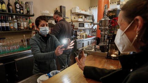 Una chica muestra en el móvil su certificado covid digital de la UE que ha tenido que enseñar al entrar en una cafetería de Sevilla este 20 de diciembre de 2021. Una chica muestra en el móvil su certificado covid digital de la UE que ha tenido que enseñar al entrar en una cafetería de Sevilla este 20 de diciembre de 2021.