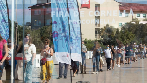 Una cola de personas esperan para entrar al centro de vacunación masiva, instalado en la Fira de Cornellà (Barcelona)