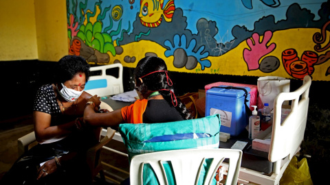 Una mujer recibe una dosis de la vacuna contra la covid en Bangalore, India.