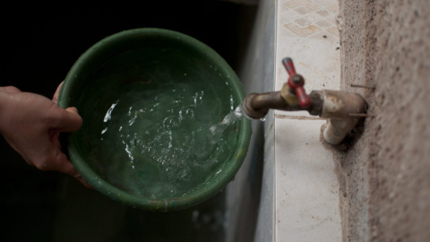 Detalle de la mano de una persona sacando agua del grifo. Detalle de la mano de una persona sacando agua del grifo.