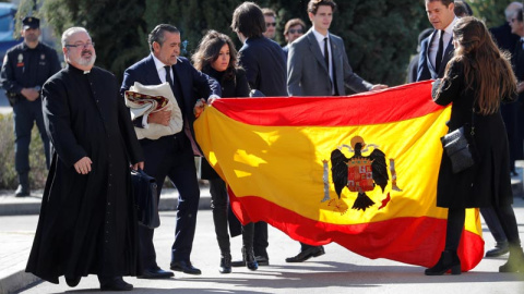 Familiares de Franco despliegan una bandera preconstitucional en el cementerio de Mingorrubio. (SUSANA VERA | REUTERS)