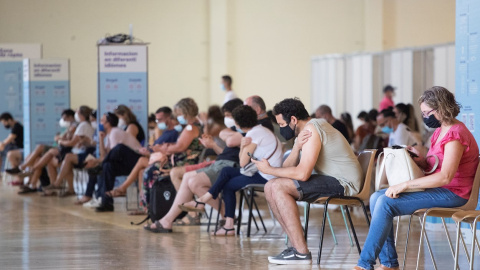 Una cola de personas en una sala del centro de vacunación masiva, instalado en la Fira de Cornellà (Barcelona). Una cola de personas en una sala del centro de vacunación masiva, instalado en la Fira de Cornellà (Barcelona).
