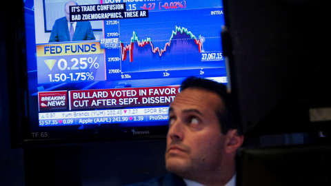 Un monitor de televisión informa de la nueva rebaja de tipos en EEUU, en el patio de negociación de la Bolsa de Nueva York, en Wall Street. REUTERS/Brendan McDermid Un monitor de televisión informa de la nueva rebaja de tipos en EEUU, en el patio de negociación de la Bolsa de Nueva York, en Wall Street. REUTERS/Brendan McDermid