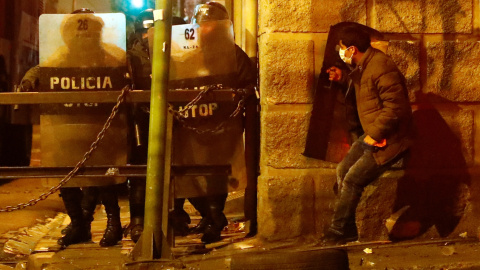 07/11/2019 -. Un manifestante detrás la pared donde están los agentes de policía durante los enfrentamientos entre manifestantes contra el presidente de Bolivia, Evo Morales, y simpatizantes del gobierno, en La Paz, Bolivia / REUTERS (Kai Pfaffenbach)