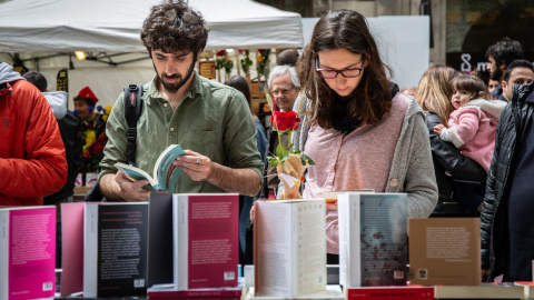Dos personas miran libros en el día de Sant Jordi en Barcelona. Dos personas miran libros en el día de Sant Jordi en Barcelona.