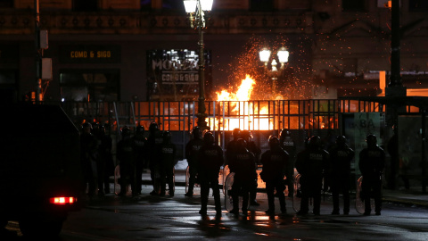 Policías son vistos frente a una barricada cuando activistas pro-abortistas encendieron fuego en Buenos Aires - REUTERS/Agustin Marcarian