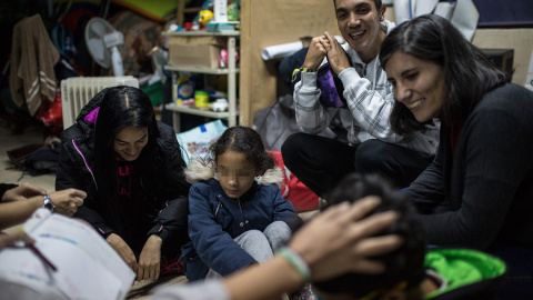 Julio Aponte junto a su mujer Margareth Jiménez (izquierda), juegan con sus hijos y la abogada Patricia Fernández en la habitación de la parroquia San Carlos Borromeo de Entrevías, donde llevan casi cinco meses esperando un plaza en el sistema de asil Julio Aponte junto a su mujer Margareth Jiménez (izquierda), juegan con sus hijos y la abogada Patricia Fernández en la habitación de la parroquia San Carlos Borromeo de Entrevías, donde llevan casi cinco meses esperando un plaza en el sistema de asil
