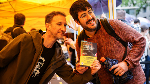 El periodista Manel Alías sostenint un exemplar del seu llibre amb un dels seus lectors al centre de Barcelona per Sant Jordi. El periodista Manel Alías sostenint un exemplar del seu llibre amb un dels seus lectors al centre de Barcelona per Sant Jordi.