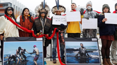 Activistas y líderes indígenas de 350.org durante la protesta que han protagonizado este domingo ante la sede de Repsol de Méndez Álvaro, en Madrid, para protestar contra la contaminación por petróleo y la industria de combustibles fósiles en Brasi
