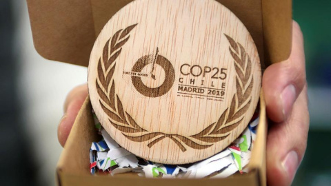Detalle de las medallas conmemorativas de la Cumbre del Clima, un disco de madera grabado con los logotipos de la COP25 y de Naciones Unidas, diseñadas y fabricadas por una empresa domiciliada en Soria (Trofeos Romero) a partir de madera excedente de los