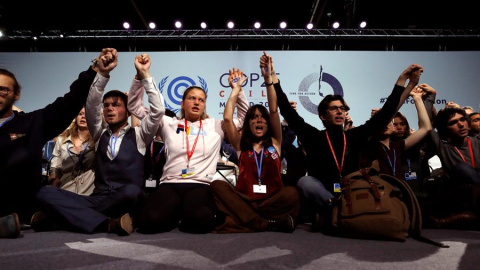 Varios activistas alzan sus manos después de la sesión plenaria de la Cumbre Climática, en el segundo día de negociaciones de alto nivel para tomar medidas adicionales contra la emergencia climática este miércoles en Ifema en Madrid. EFE/ J.J. Guill