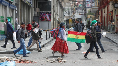 Gente paseando por las calles con una bandera de Bolivia. / EFE Gente paseando por las calles con una bandera de Bolivia. / EFE