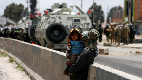 Una mujer sostiene a su hijo mientras los militares avanzan para atacar a los manifestantes contrarios al golpe de Estado en Bolivia, junto a la planta gasística de Sentaka, en El Alto, Bolivia.- REUTERS / DAVID MERCADO