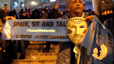 18/12/2019.- Una mujer con una careta de Messi y un cartel de Tsunami Democràtic. / EFE- TONI ALBIR